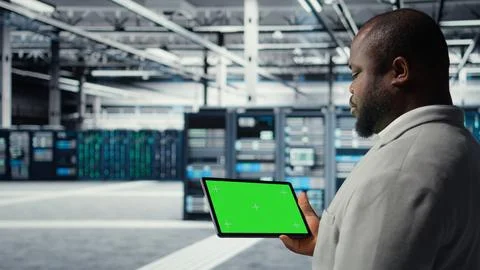 Engineer in data center using mockup tablet to develop disaster recovery plans Stock Photos
