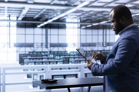 Engineer in data center using tablet to identify and solve technical issues Stock Photos
