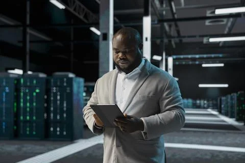Engineer in data center using tablet to check for server performance issues Stock Photos