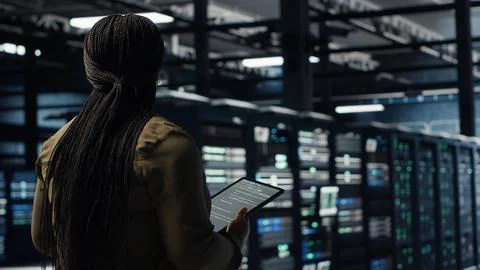 Engineer in data center using tablet to deploy secure server architecture Stock Photos