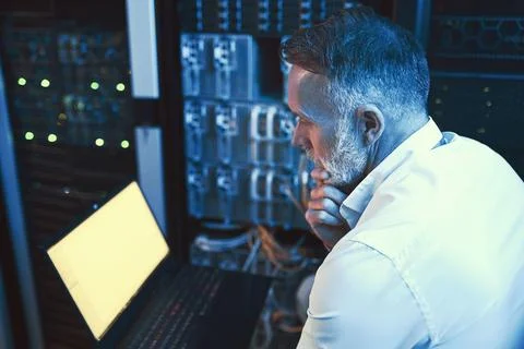 Engineer, decision and man with laptop screen in server room, reading or Stock Photos