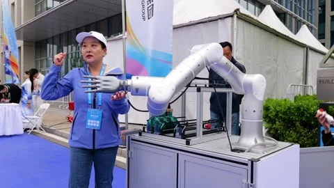 Engineer demonstrates advanced robotic arm at Beijing E-Town tech expo Stock Footage 309111919