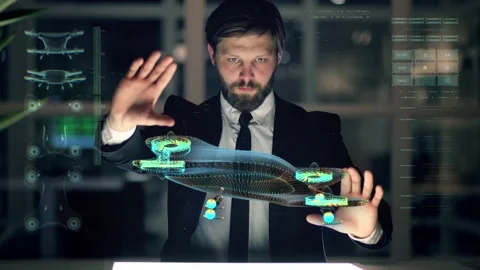An engineer designs an electric drone using futuristic programs and holographic Stock Footage 148352012