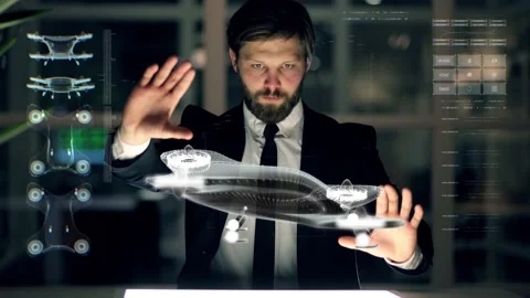 An engineer designs an electric drone using futuristic programs and holographic Stock Footage 148386011