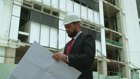 An engineer, developer at a construction site checks on the drawings at what Video stock 162342596