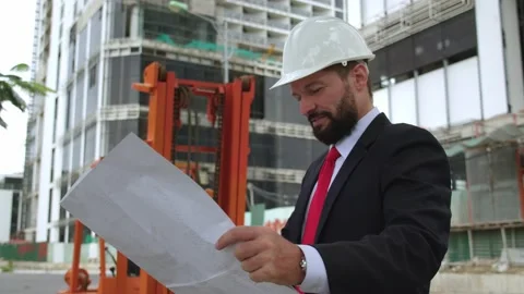 An engineer, a developer at a construction site, checks the drawings, at what Stock Footage 163430417