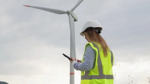 The engineer develops a wind farm project on her digital tablet, creating 스톡 동영상 274297972