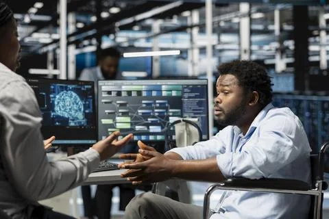 Engineer with disability and manager inspecting neural network data center 스톡 사진