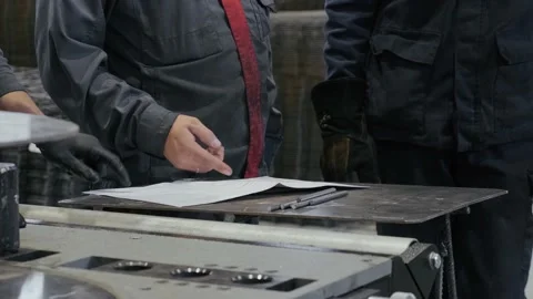 The engineer discusses the work plan with the workers. Working hands point a Stock Footage 163574385