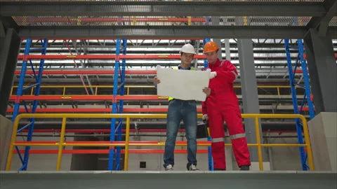 Engineer discussing blueprints of electric train machinery Stock Footage 253818417