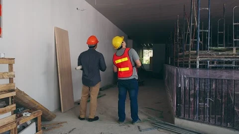 Engineer discussing with foreman about project in building construction site Stock Footage 172086793