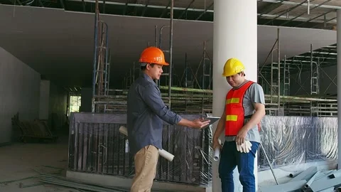 Engineer discussing with foreman about project in building construction site Stock Footage 184534613