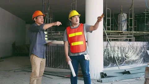 Engineer discussing with foreman about project in building construction site Stock Footage 242904085