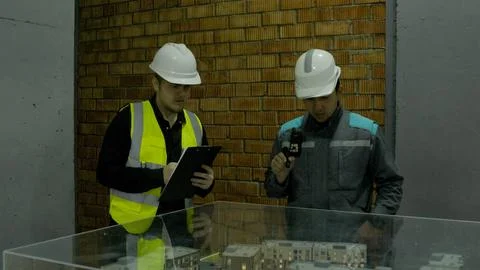 Engineer discussing site progress with construction workers on the roof Stock Photos