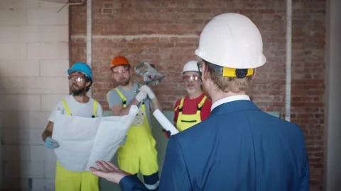 Engineer discussing structure of building with workers at construction site. Stock Footage 133639859