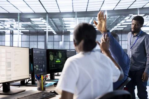 Engineer doing high five gesture with colleague in data center Stock Photos