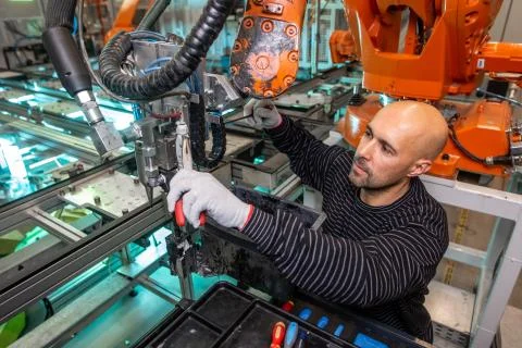 Engineer doing maintenance on a automatic robot arms in automotive industrial Stock Photos