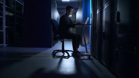 Engineer doing network diagnostics on digital laptop and sitting at table in Stock Footage 166837448