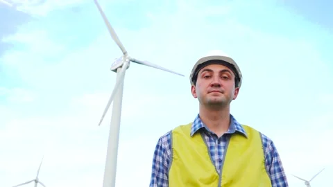 Engineer doing yes gesture by nodding his head in front of wind turbines Stock Footage 137968392
