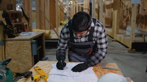 Engineer drafting modular home plan at construction site Stock Footage 301827359