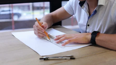 The engineer draws a drawing for the builders on the paper Stock Footage 87128505