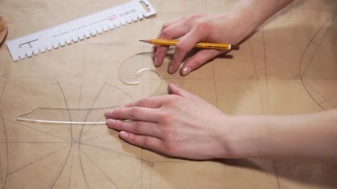 The engineer draws on a paper with a pencil, tailor makes pattern for seawing Stock Footage 78001395