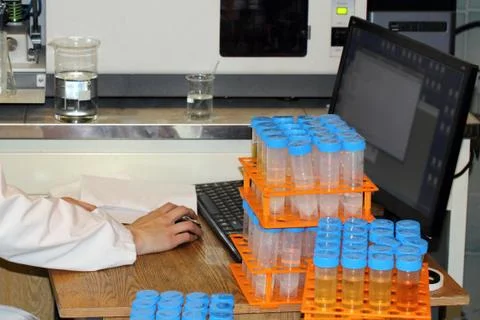 Engineer ecologist analyzes the computer. Test tubes with samples of soil, wa Stock Photos