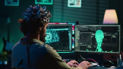 Engineer with EEG headset on merging with artificial intelligence Stock Footage 266954123