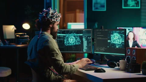 Engineer with EEG headset on merging with artificial intelligence Stock Footage 266954242