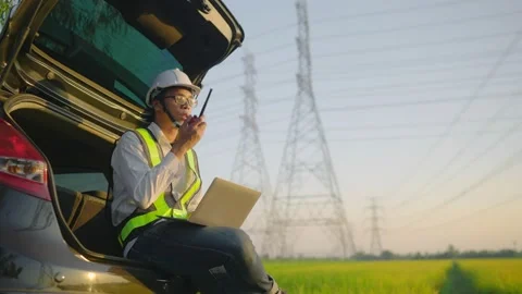 Engineer Electric talking on walkie talkie near high voltage tower. Видео 148355602