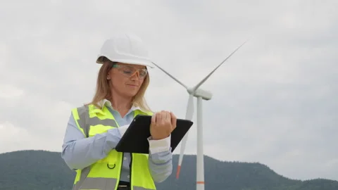 An engineer with an electronic tablet develops a strategy for renewable wind Stock Footage 265294928