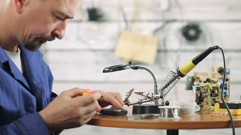 The engineer is engaged in repair of the old mobile phone Stock Footage 98981163