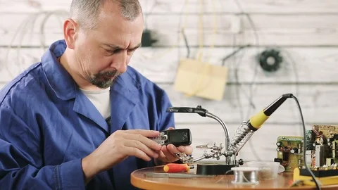 The engineer is engaged in repair of the old mobile phone Stock Footage 98982677
