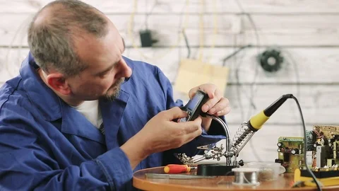 The engineer is engaged in repair of the old mobile phone Stock Footage 98983038