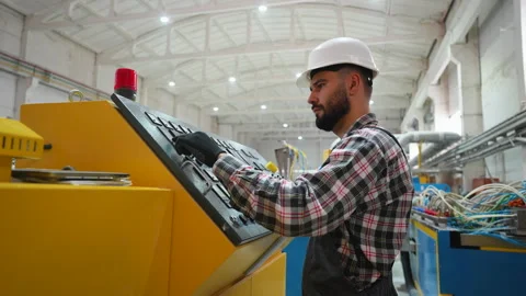 Engineer entering data in CNC machine at pvc window factory to get the Stock Footage 314583295