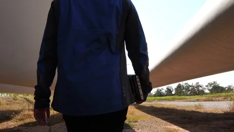 An engineer evaluates wind turbine with a tablet  Stock Footage 121204215