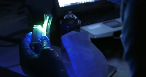 Engineer examines part under ultraviolet light during non-destructive inspection Stock Footage 108774748