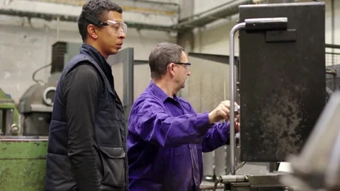 Engineer explain to a worker to use a control panel Stock Footage 258181738