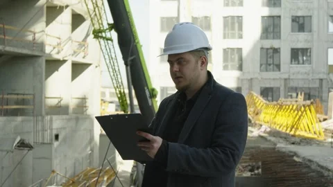 Engineer explaining construction details and pointing on the building site Stock Footage 323172101
