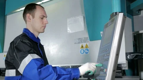 Engineer at the factory controlled hydraulic bending machine CNC. Man carefully Stock Footage 71654133