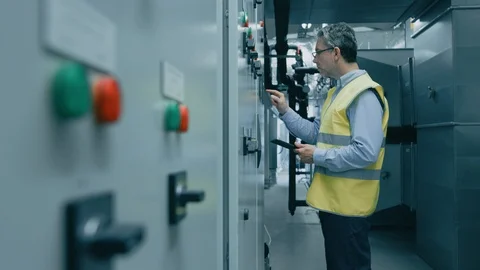 Engineer / Factory Worker Programming / Setting Up Machinery on a Power Station. Stock Footage 93228364