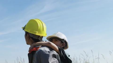Engineer father and his son playing Piggyback in a wind turbine field Stock Footage 165067578