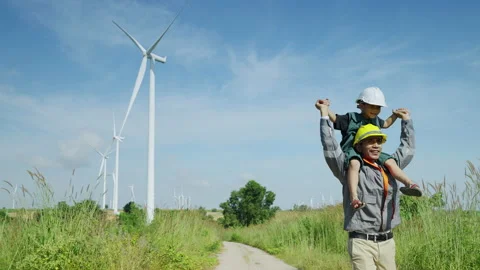Engineer father and his son playing Piggyback in a wind turbine field Stock Footage 167147639