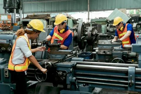 Engineer with Female mechanical worker checking on production in a factory. Stock Photos