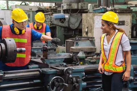 Engineer with Female mechanical worker  checking on production in a factory. Stock Photos