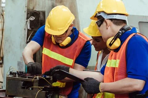 Engineer with Female mechanical worker  checking on production in a factory. Stock Photos