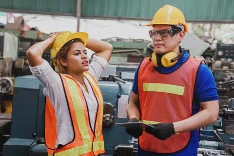 Engineer with Female mechanical worker   checking on production in a factory. Stock Photos