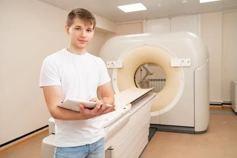 Engineer fills after maintenance documents. computer tomograph. Stock Photos