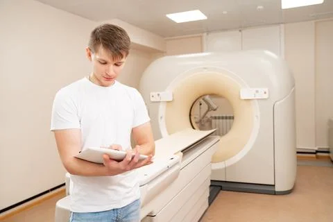 Engineer fills after maintenance documents. computer tomograph. Stock Photos