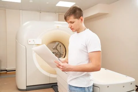 Engineer fills after maintenance documents. computer tomograph. Stock Photos